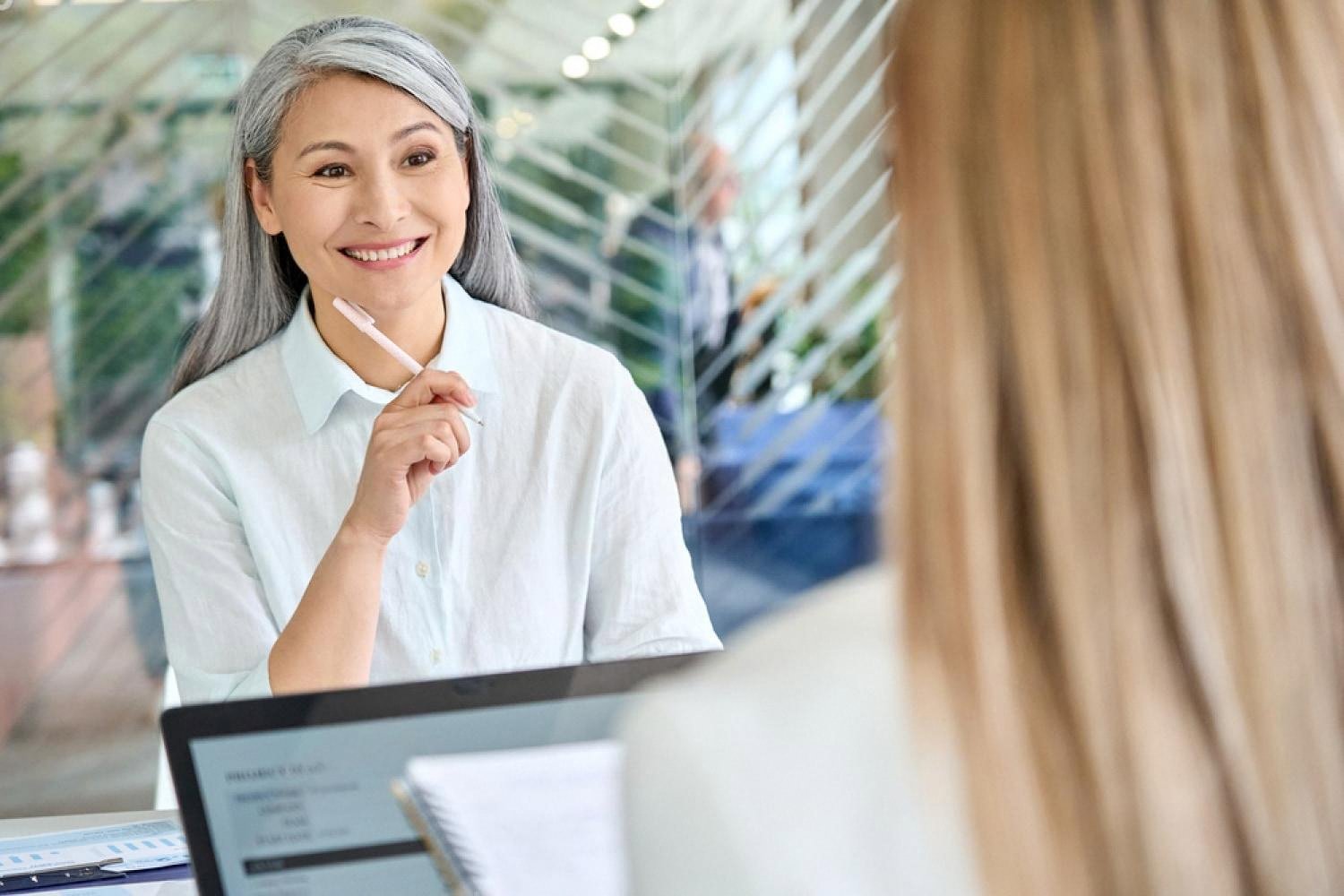Smiling HR manager interviewing a candidate in a bright UAE office