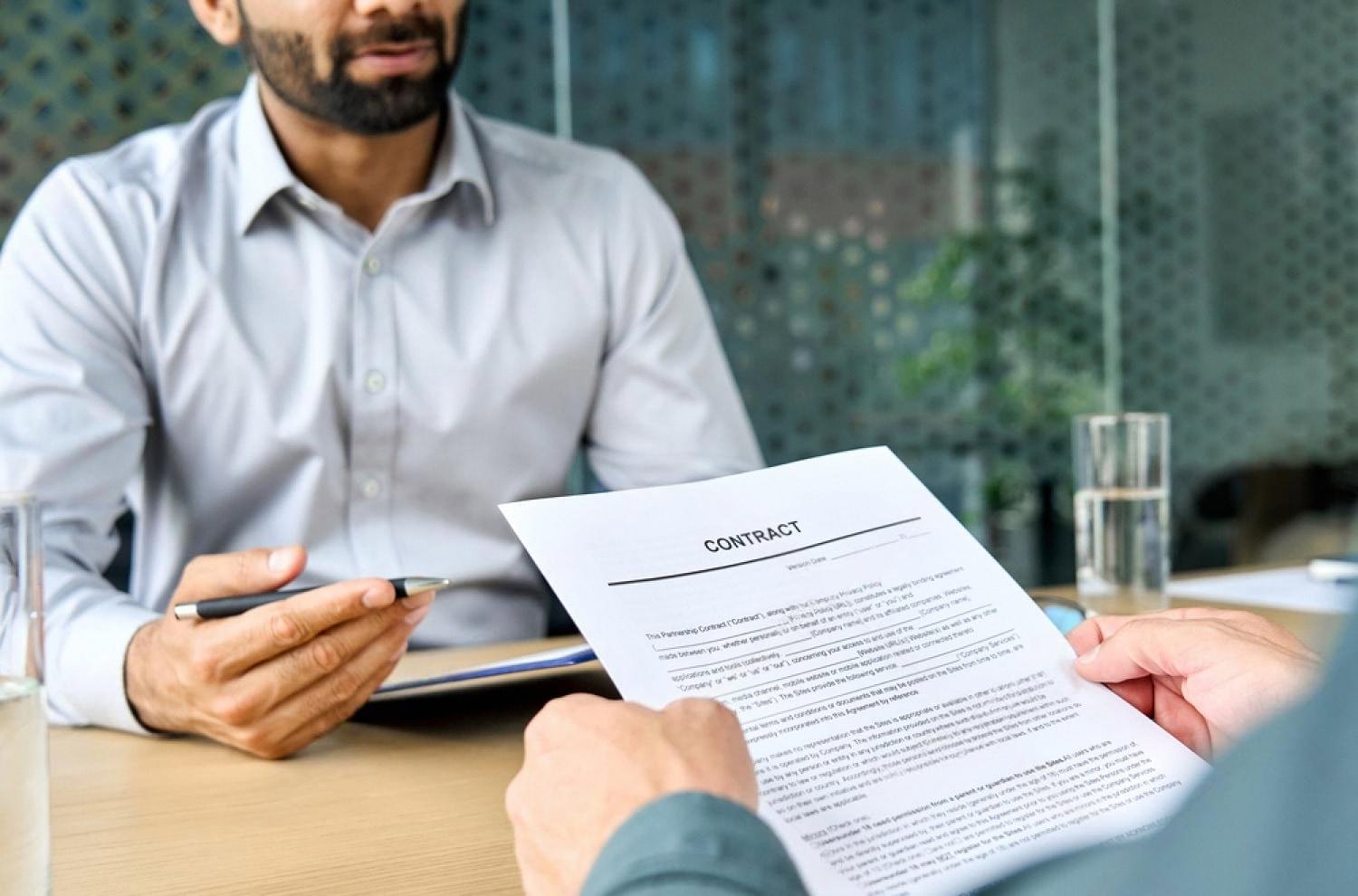 HR professional handing an employment contract to a new hire in Dubai